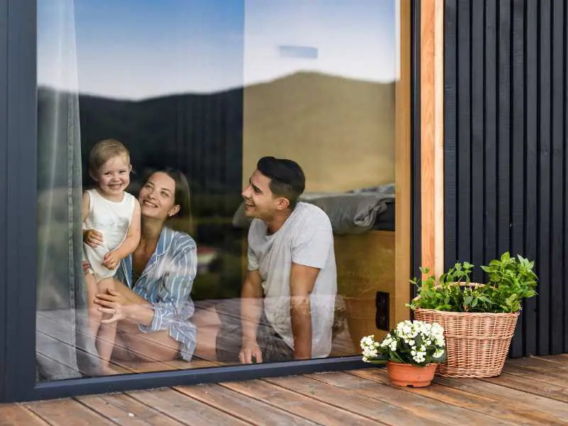 family-of-three-sitting-on-a-wooden-floor