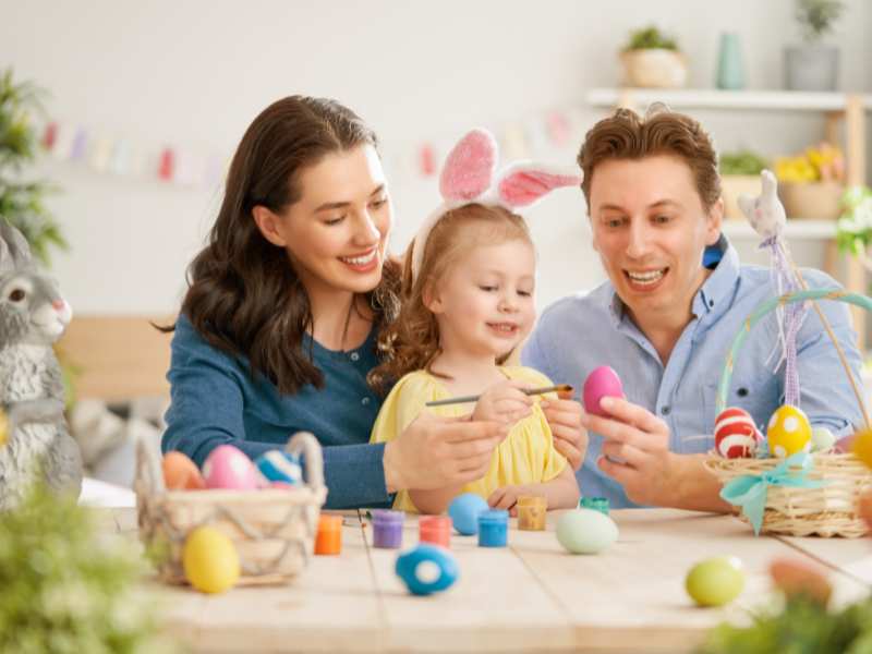 family-of-three-with-multi-colors-easter-eggs-on-the-table-an-ideal-activity-for-family-easter-traditions