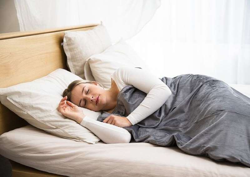 woman-sleeping-with-a-grey-bed-sheet