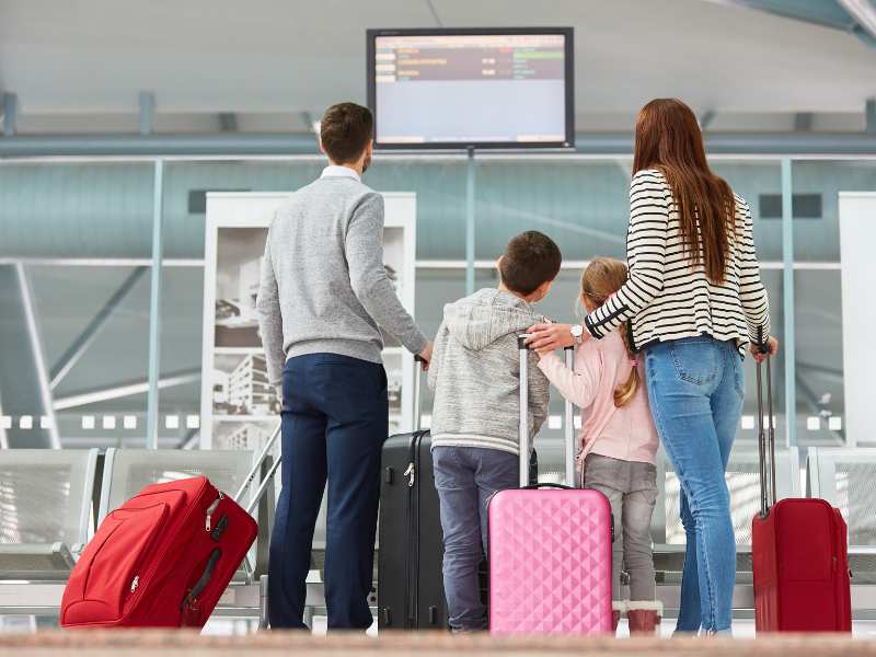 family-of-four-on-a-travel-trip-with-bags