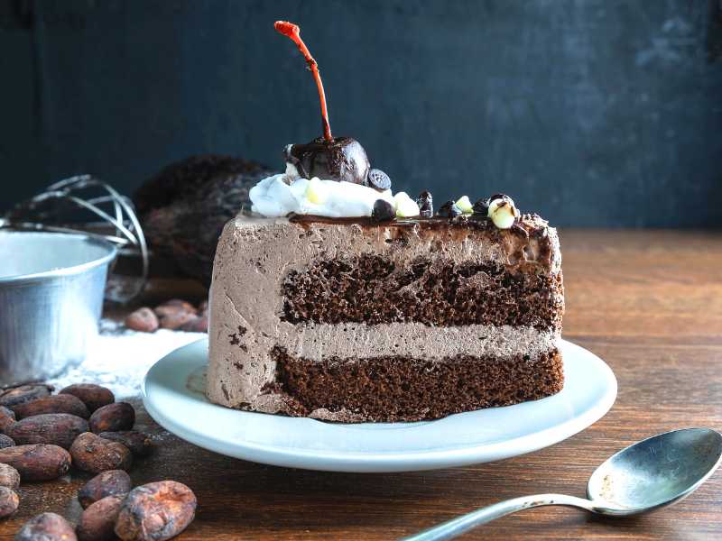 vegan-chocolate-cake-garnish-with-cream-on-a-brown-table