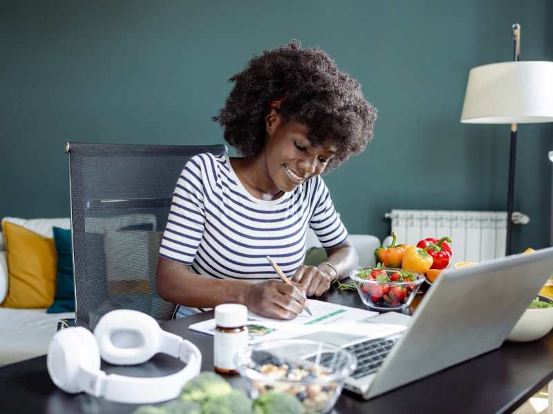 woman-writing-with-a-laptop-on-the-table