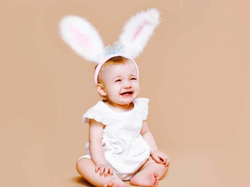a-baby-with-white-easter-bunny-onesie-sitting