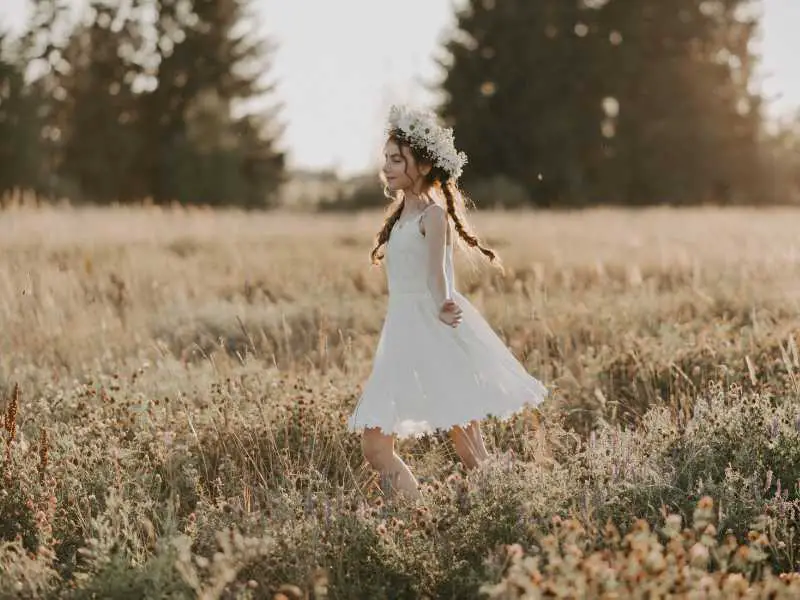 a-girl-with-a-white-gown-and-flower-crown-in-field