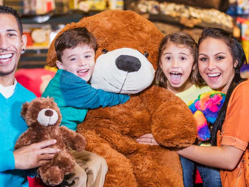 family-having-fun-and-holding-a-teddy-beer