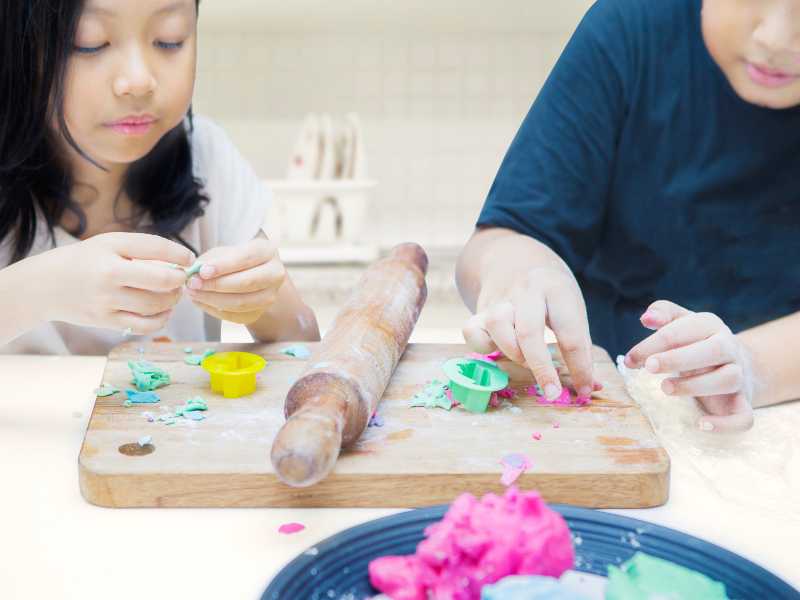 kids-molding-using-chopping-board-and-rolling-pin