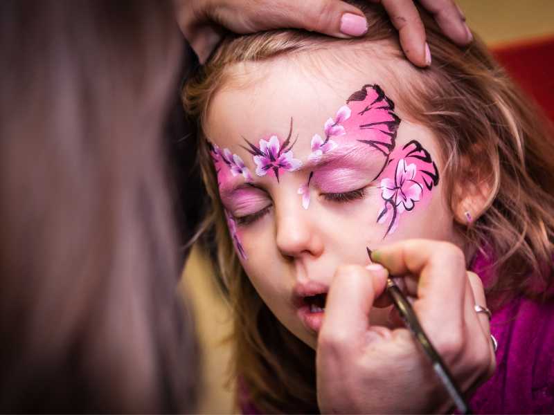 painting-a-girl-face-with-multi-color-flower
