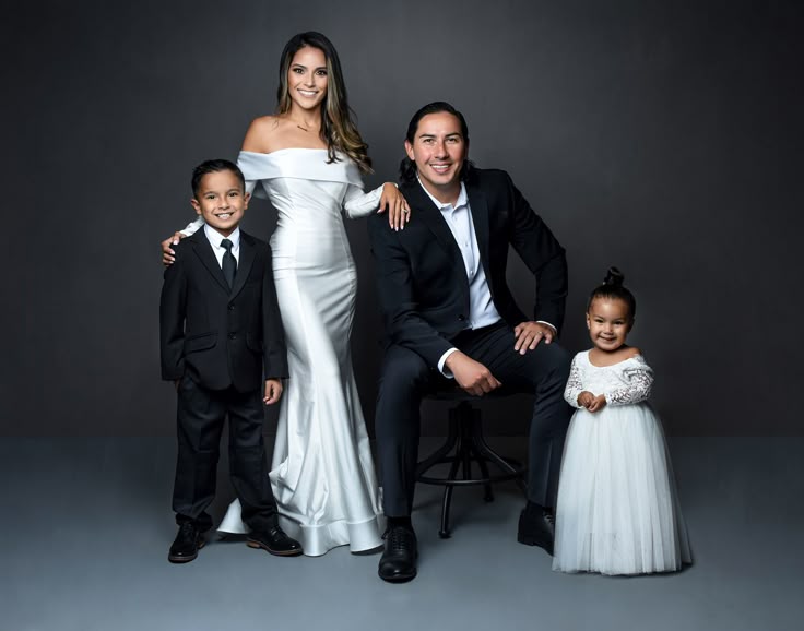 father-sitting-mother-standing-with-two-children-for-family-photo