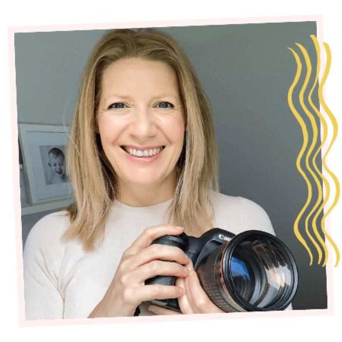 lady-holding-a-camera-in-a-grey-background