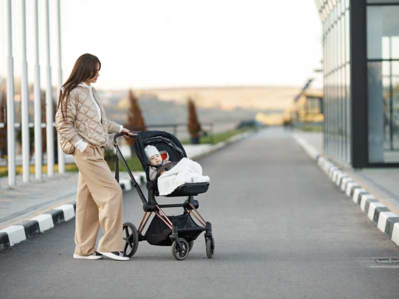 mom-using-trolley-for-shade-to-survive-summer-vacation-for-newborn