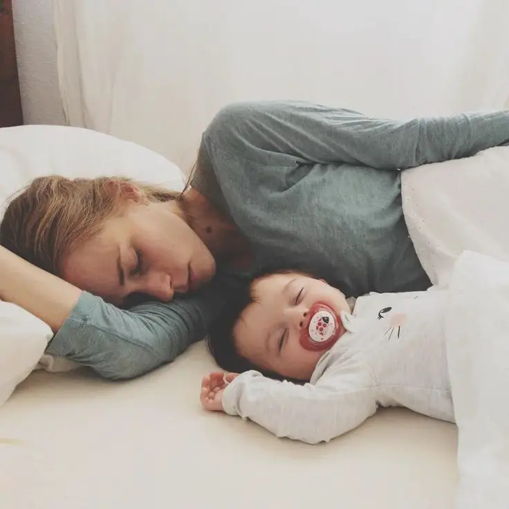 mom-sleeping-by-the-side-of-her-baby