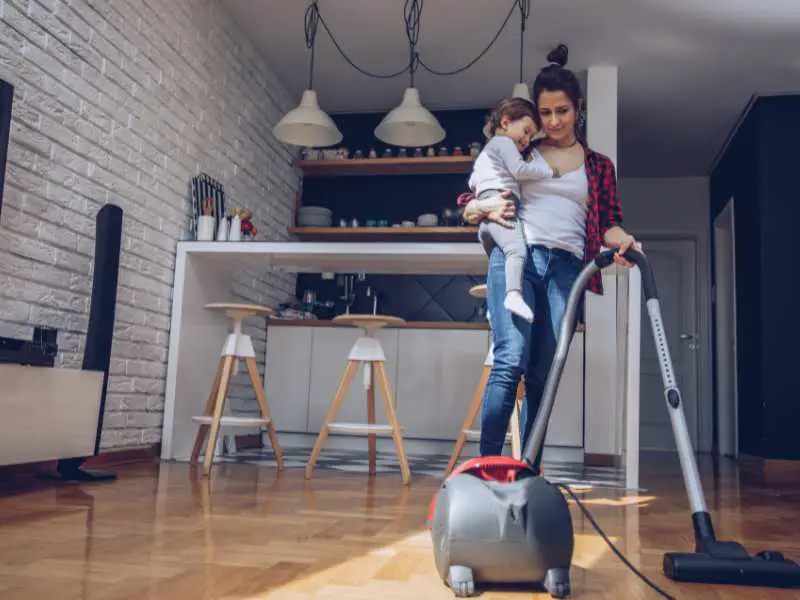 mom-carrying-a new-baby-EASY-CLEANING-SCHEDULE-FOR-BUSY-MOMS