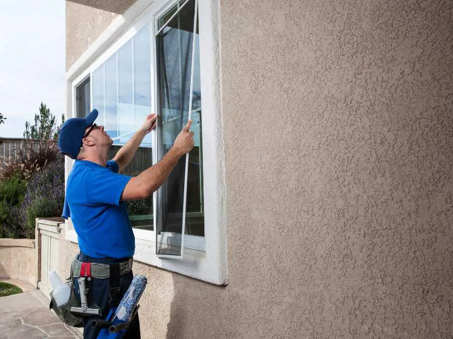 man-installing-adjustable-window-screen